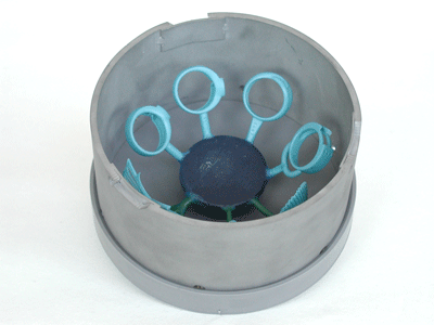 Wax models in a large metal ring for Cast by Ti-Research on a vibrating plate ready for investing